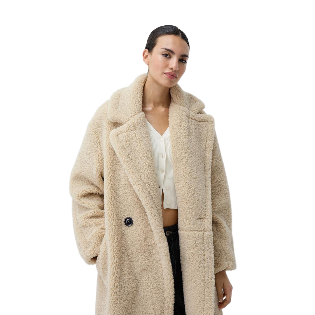 Woman wearing a beige teddy coat on a white background