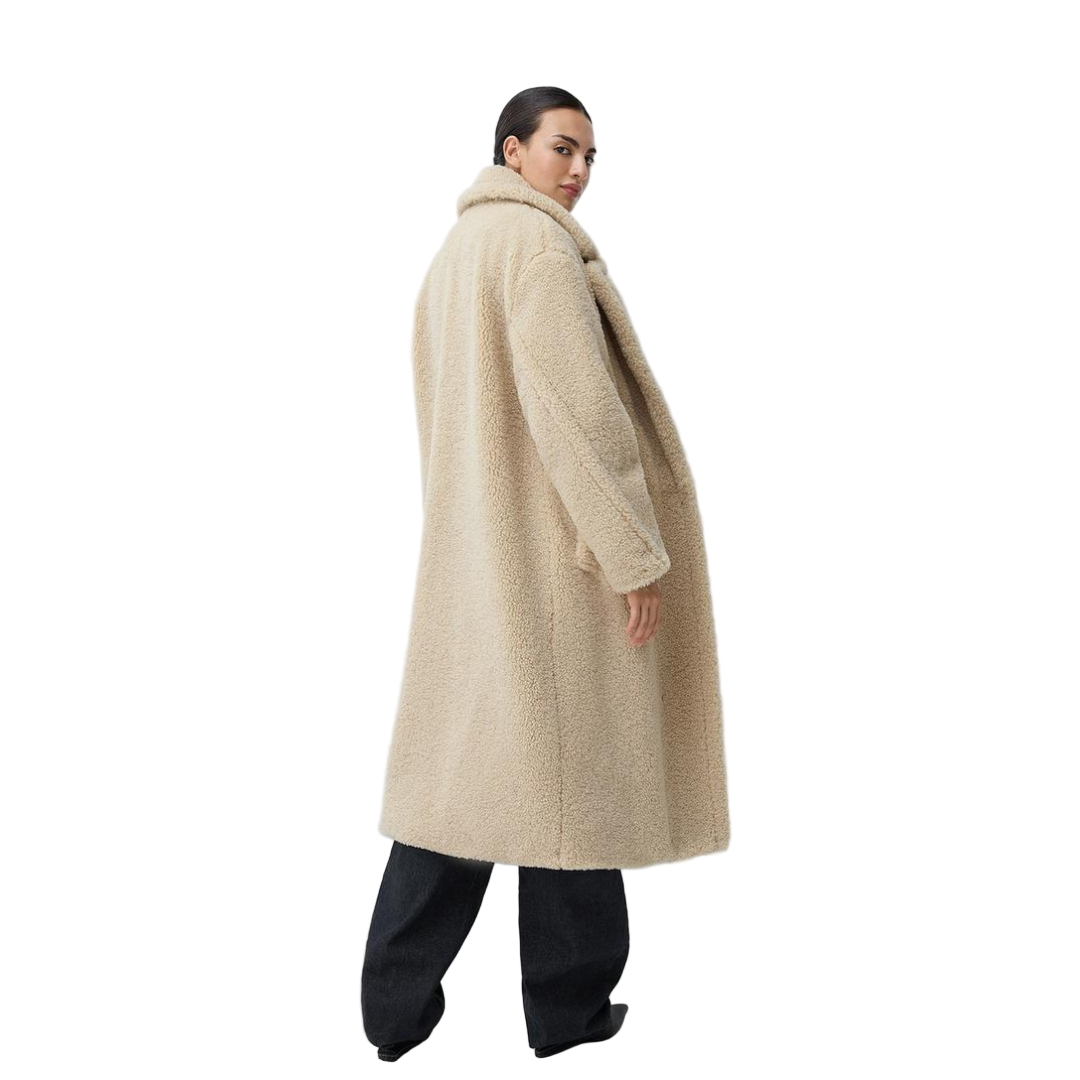 Person wearing a beige coat on a white background