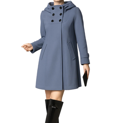 Blue coat with black buttons worn by a person on a gray background