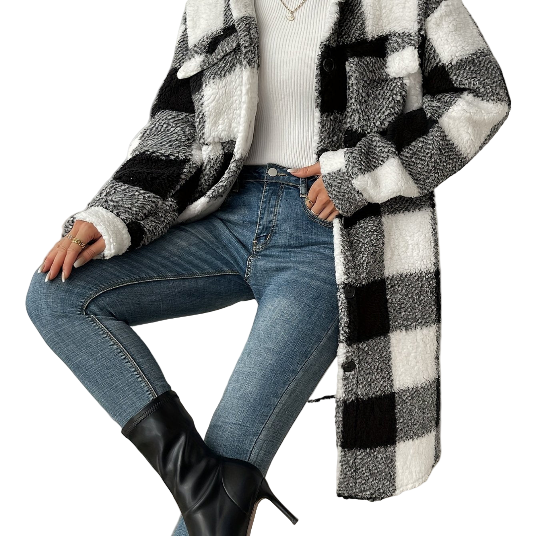 Person wearing a checkered coat, jeans, and black boots against a plain background