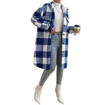 Person wearing a blue and white checkered coat holding a coffee cup indoors.